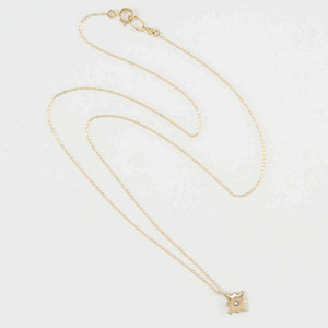 Delicate gold chain necklace with gold native motif cross pendant with inset diamond.