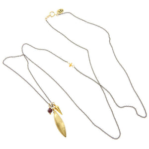 Dark chain necklace with pendant of large brass spike and small gold spike and garnet.