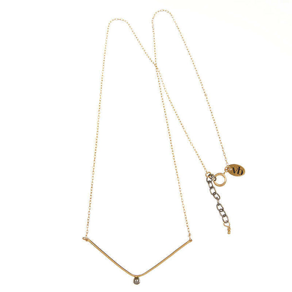 Delicate gold chain necklace, wide v pendant with dark pearl in middle.